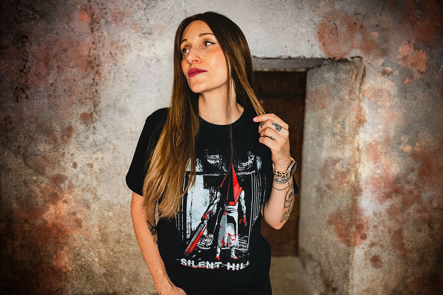 Person trägt ein schwarzes Silent Hill T-Shirt mit Pyramid Head Motiv in einer düsteren, rostfarbenen Horror-Kulisse.
